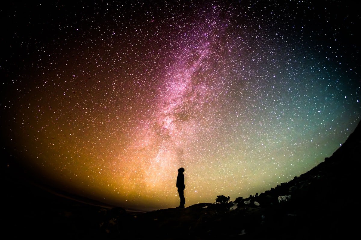 A seeker gazing at the Milky Way, symbolising life's cosmic journey